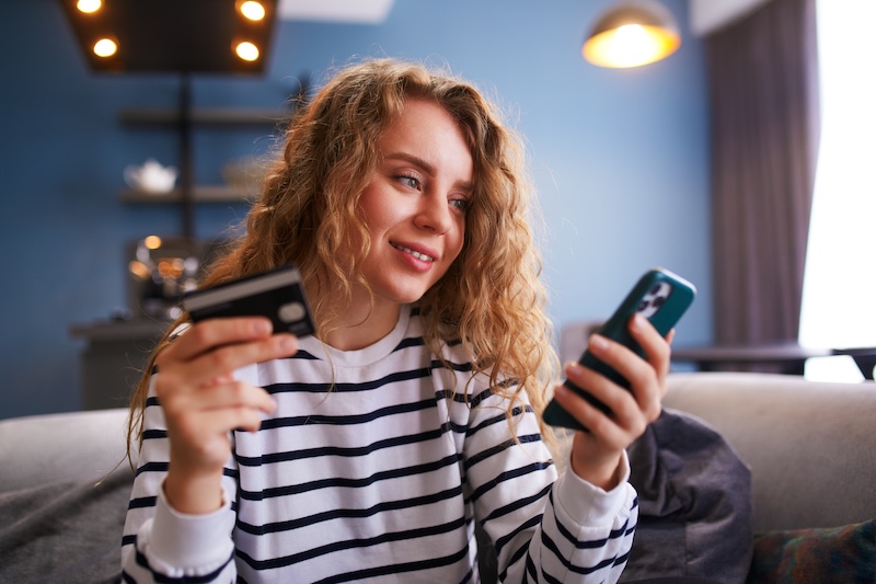 Tjej med telefon och betalkort